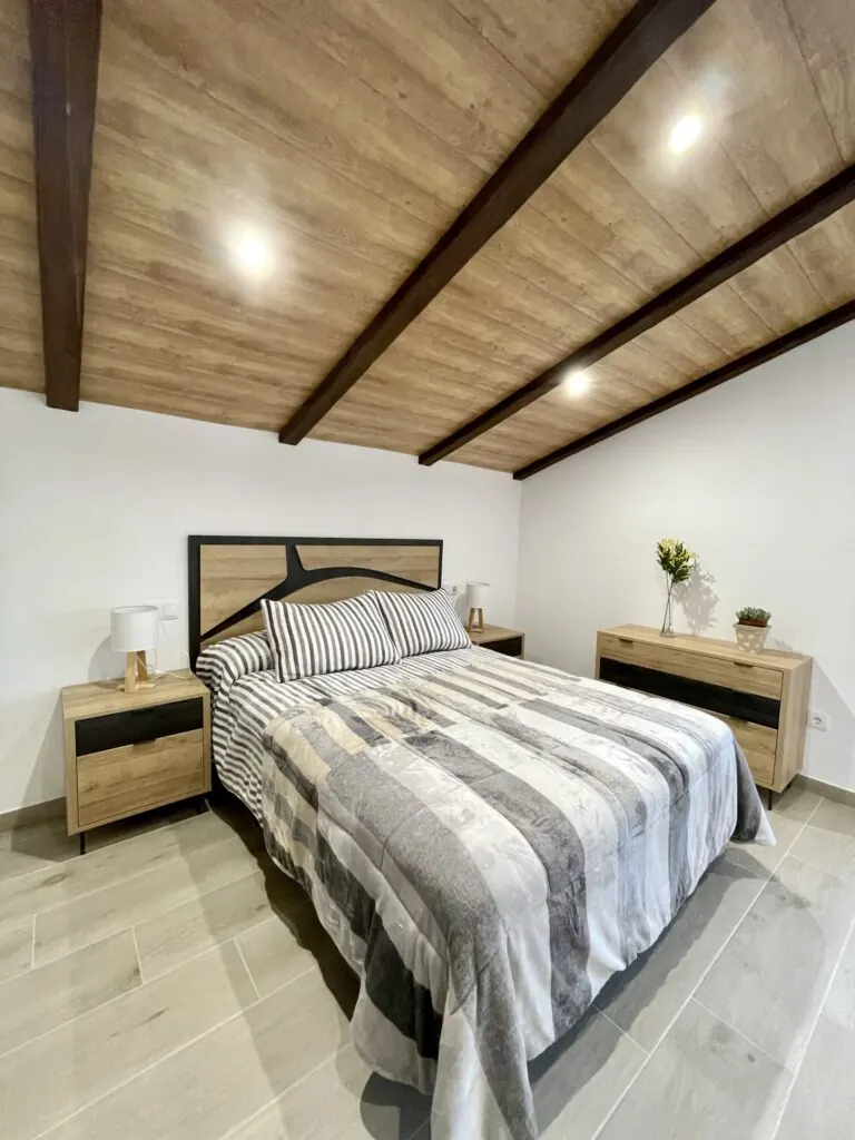 Dormitorio de matrimonio con vigas de madera en Aromas de Alcalá